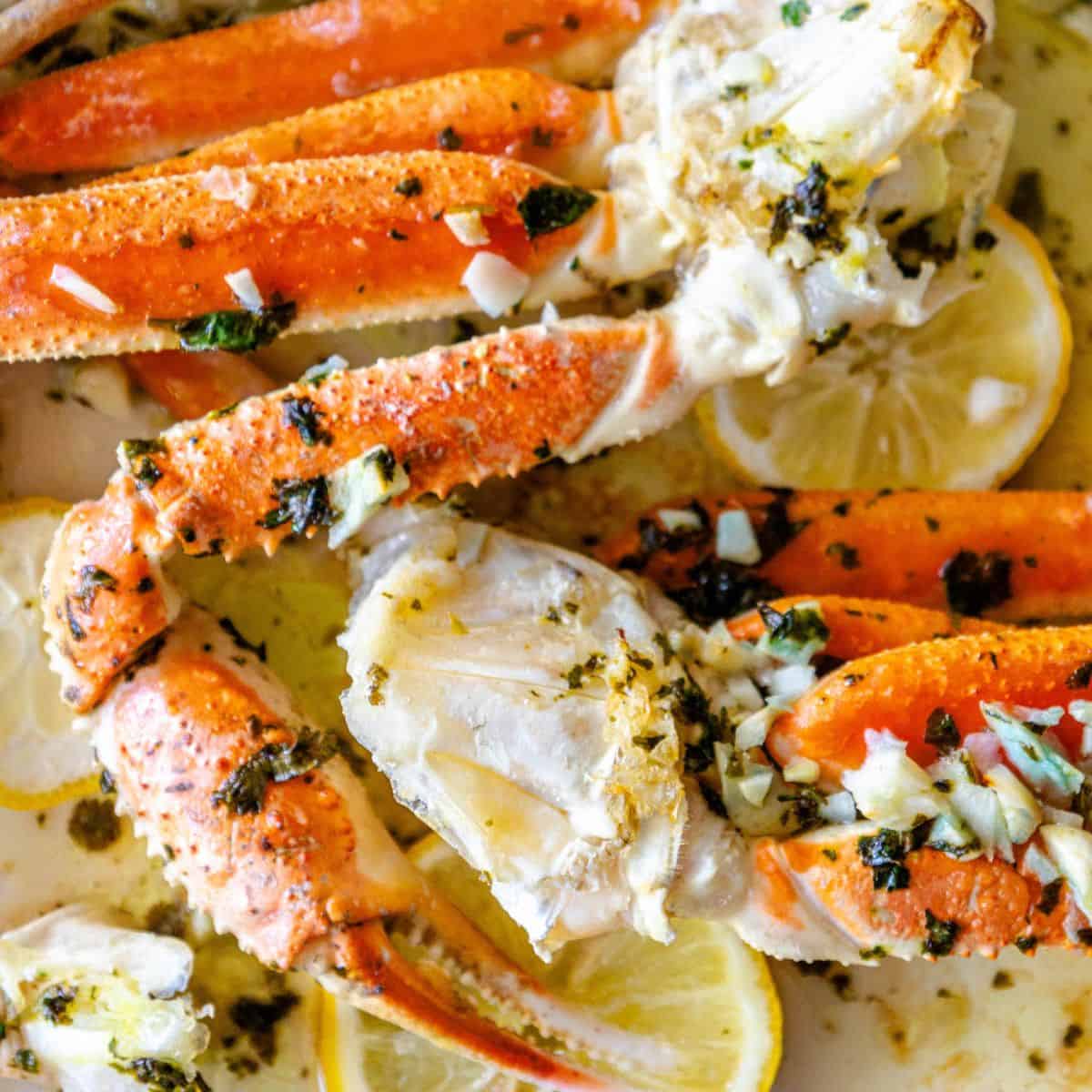 Crab legs with lemon and herbs on a plate.