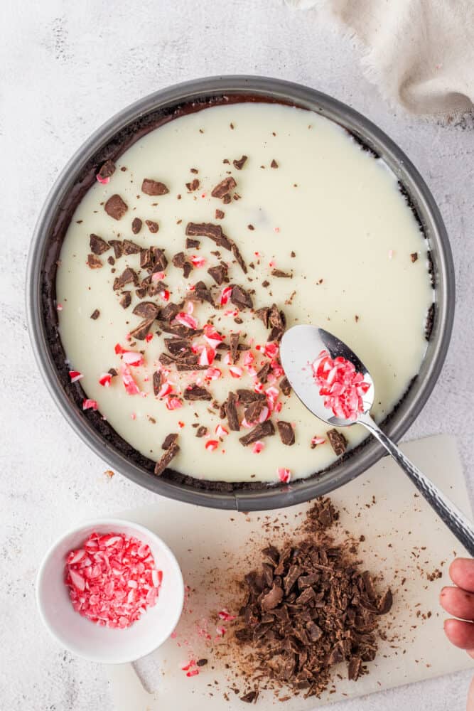 Chocolate peppermint pie in a pan with a candy cane spoon.