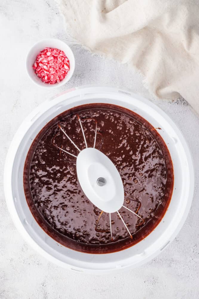 A crock pot filled with chocolate cake, drizzled with rich chocolate ganache.