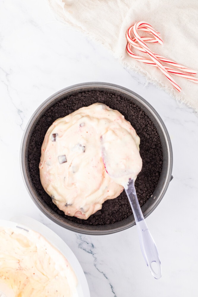 A bowl of candy cane pie with a spoon next to it.
