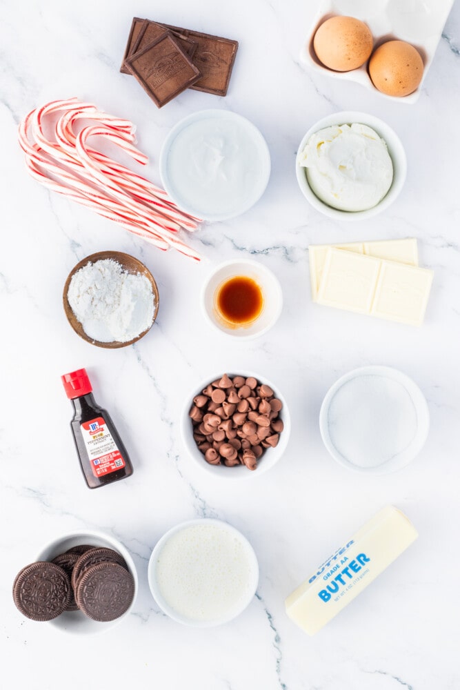 The ingredients for a candy cane cookie are laid out on a marble table.