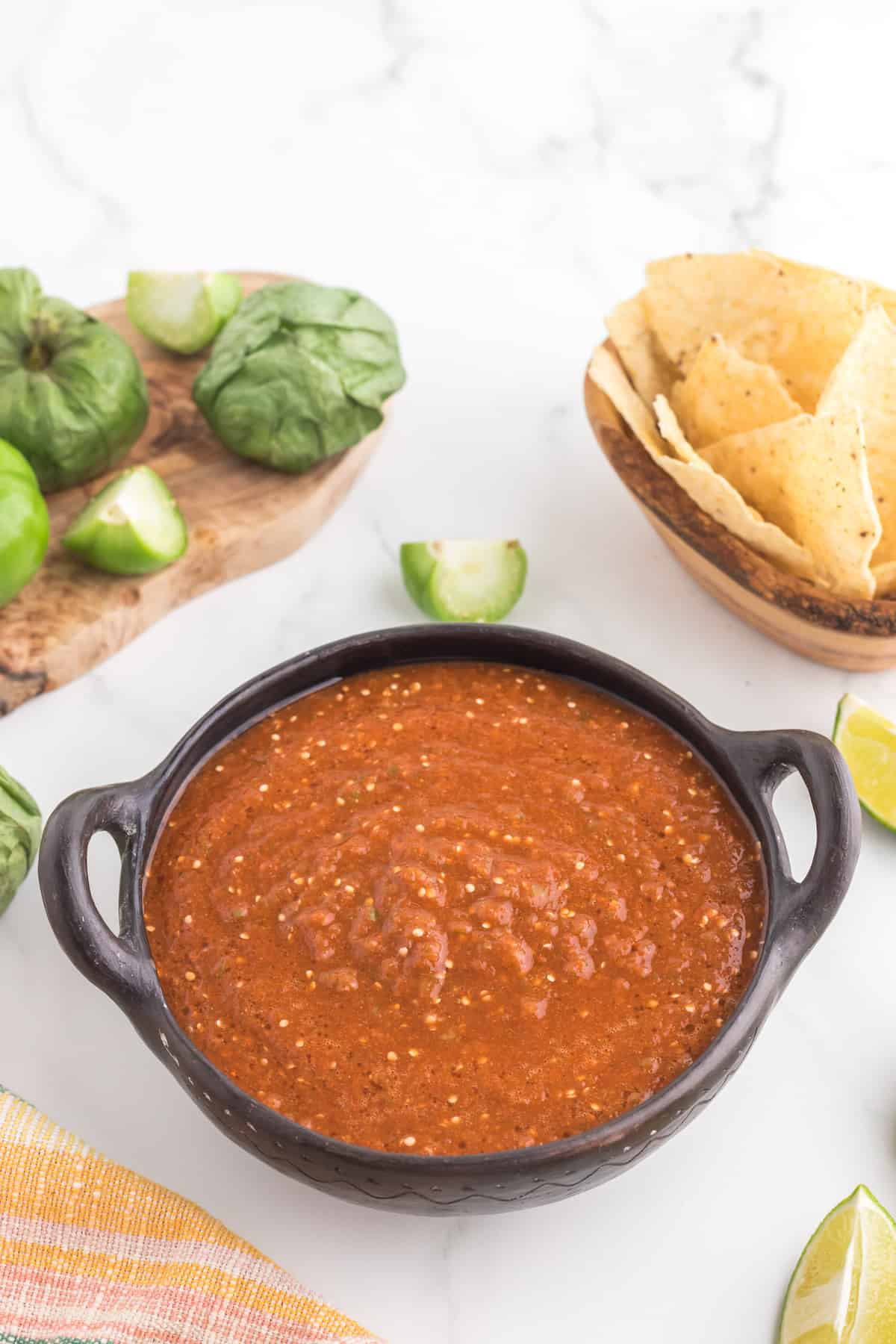 Copycat Chipotle Red Salsa served with tortilla chips and limes.