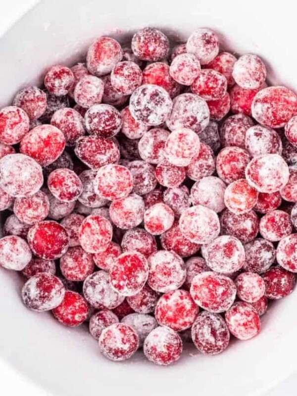 Frozen cranberries in a white bowl.