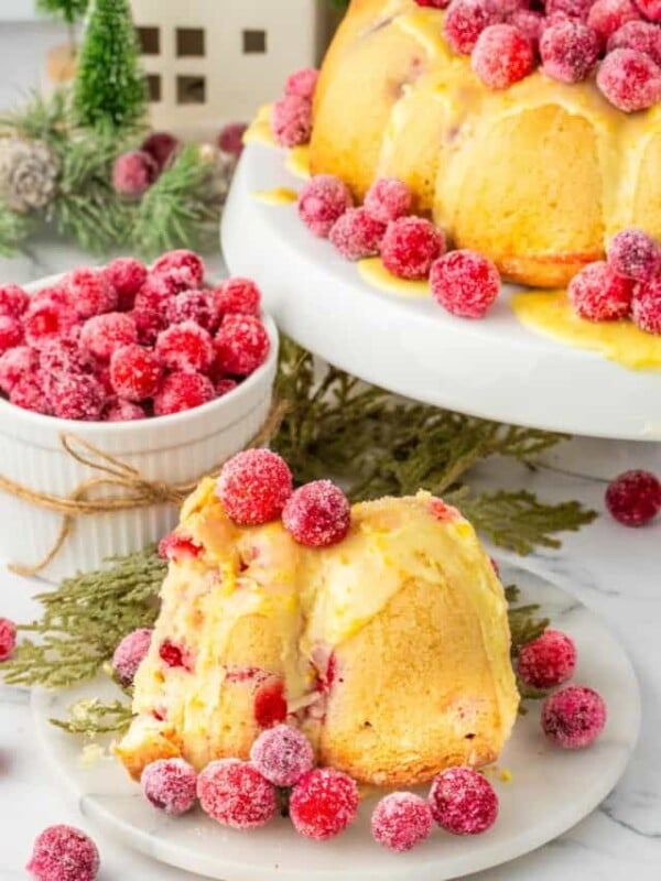 A bundt cake with cranberries on a plate.