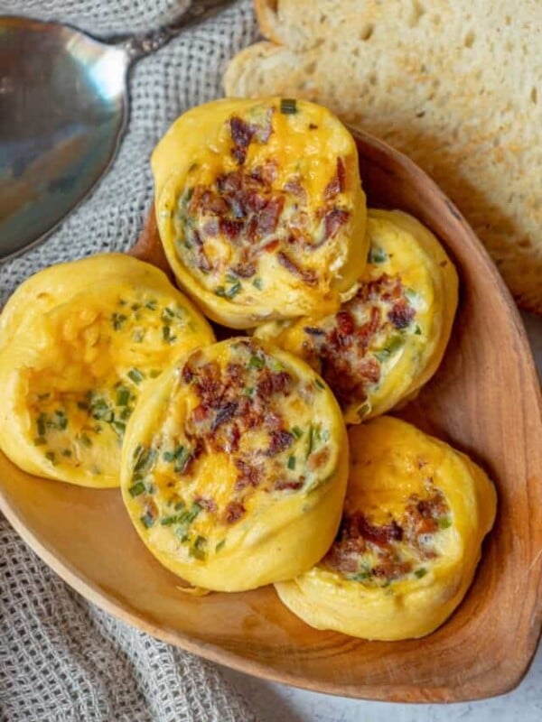 Egg muffins with bacon and cheese on a wooden plate.