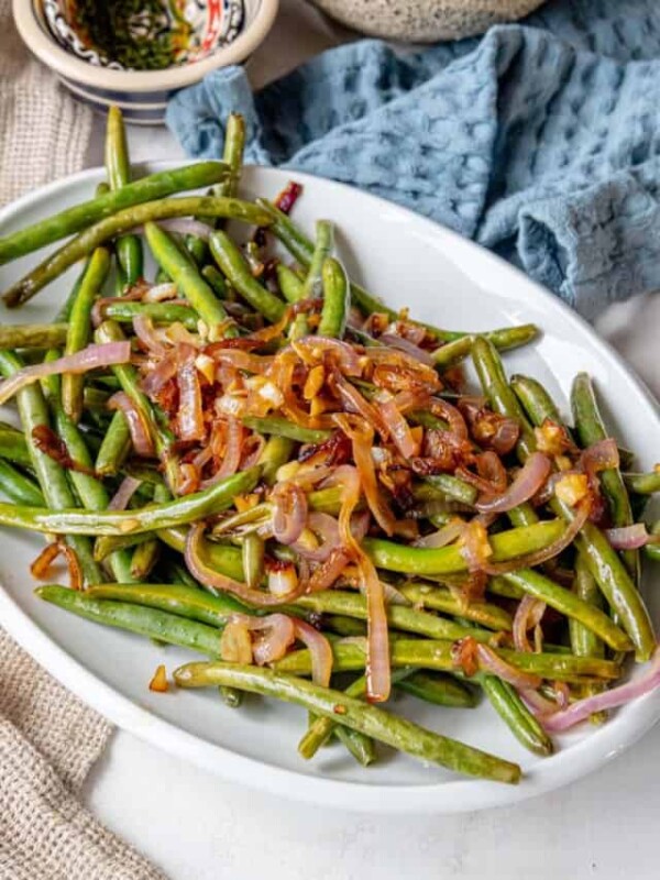 Green beans and onions on a white plate.