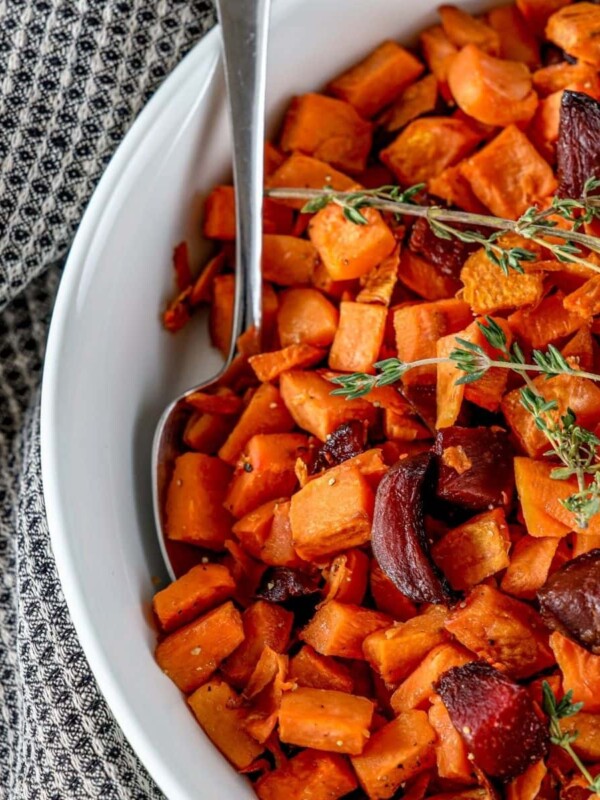 picture of roasted beets and sweet potatoes in a glass dish with thyme on top