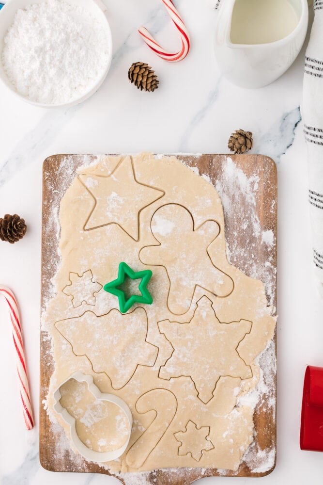 picture of sugar cookies being cut out on a cutting board