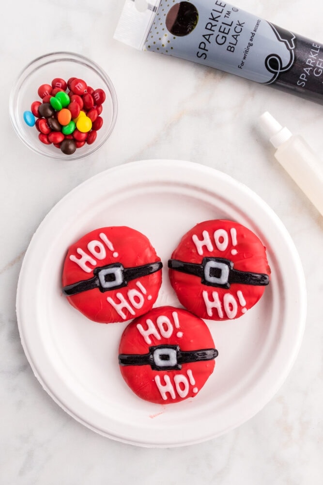 picture of a christmas cookie dipped in red candy and decorated like a santa belt