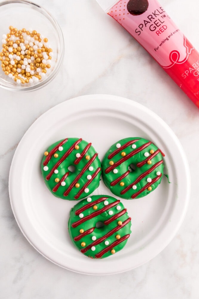 picture of cookies decorated like a green christmas wreath with icing stripes
