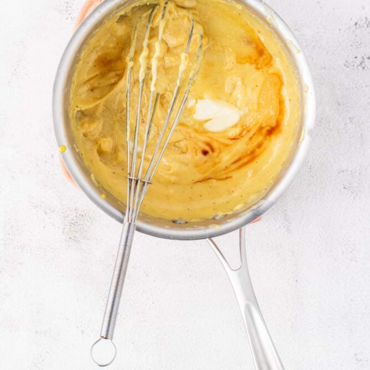 A whisk with batter in it.