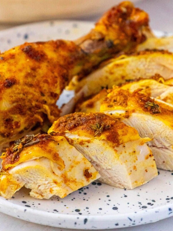sliced whole roasted chicken with turmeric and garlic on a plate