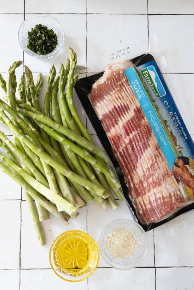 A package of bacon-wrapped asparagus on a tiled floor.