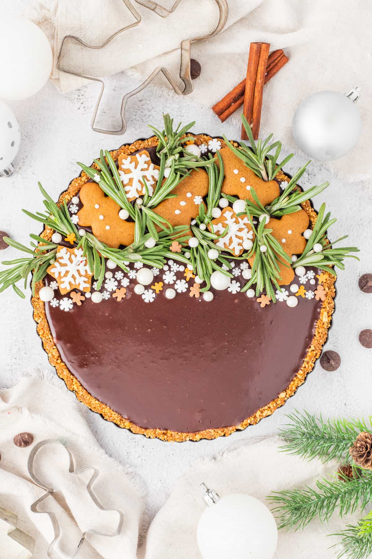 A gingerbread chocolate tart adorned with ornaments.