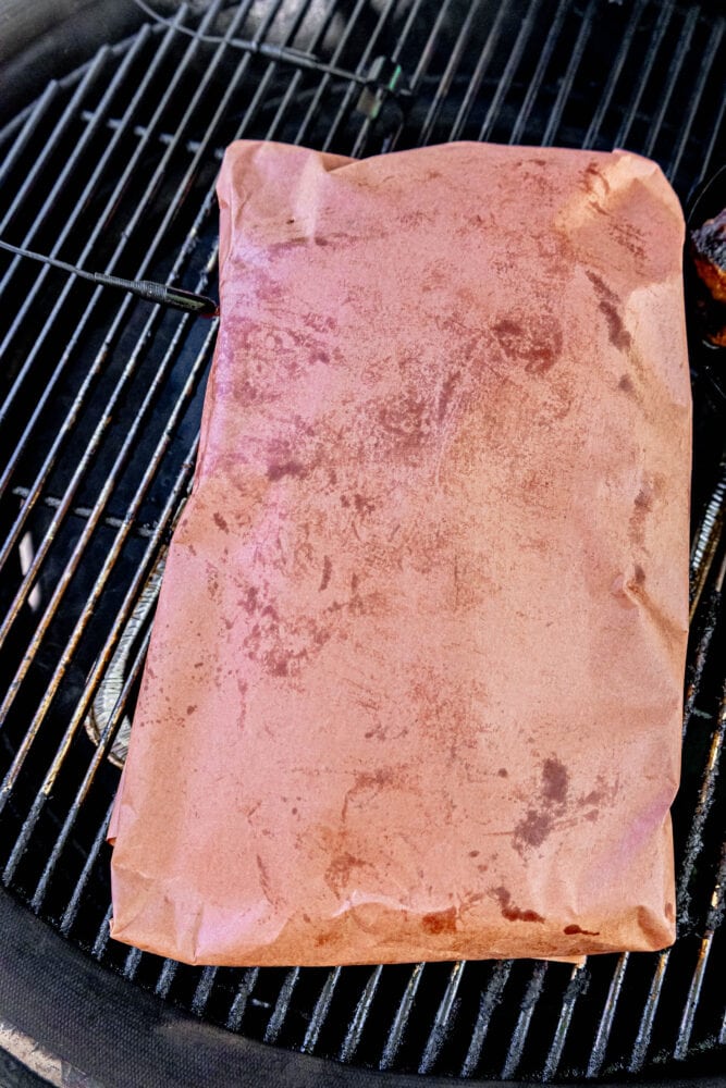 a wrapped brisket on a grill