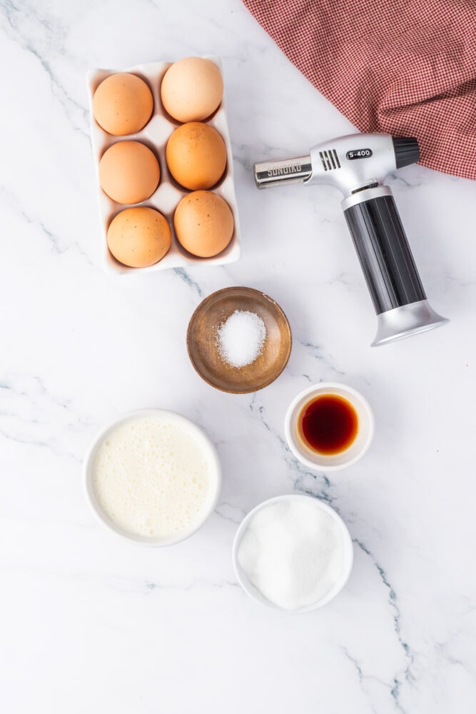 eggs, sugar, vanilla, a kitchen torch on a table