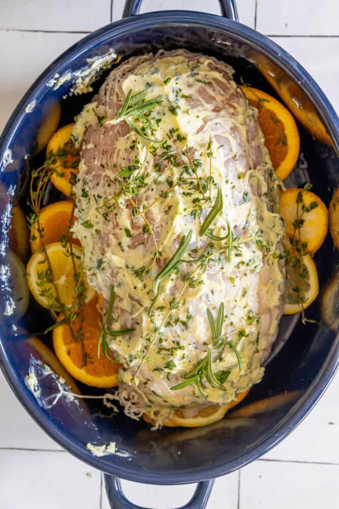 A pot filled with oven baked turkey breast and orange slices.