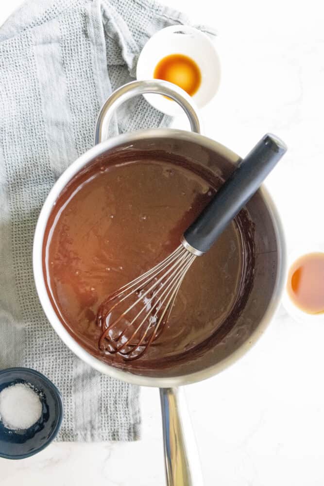 Silky chocolate sauce in a pan with a whisk.