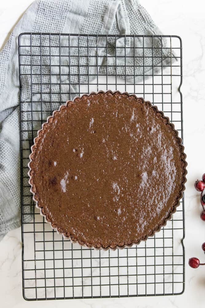A silky chocolate tart on a cooling rack.
