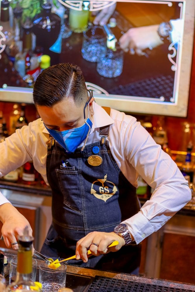 picture of a bartender at Good Spirits bar on Majestic Princess cruise ship in a face mask