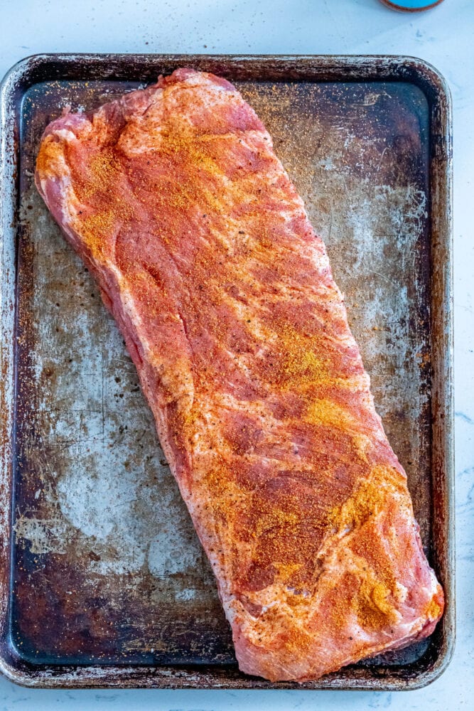 picture of seasoned ribs on a baking sheet