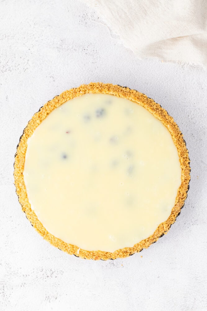 A white pie with blueberry filling on a white surface. White Blueberry Pie.