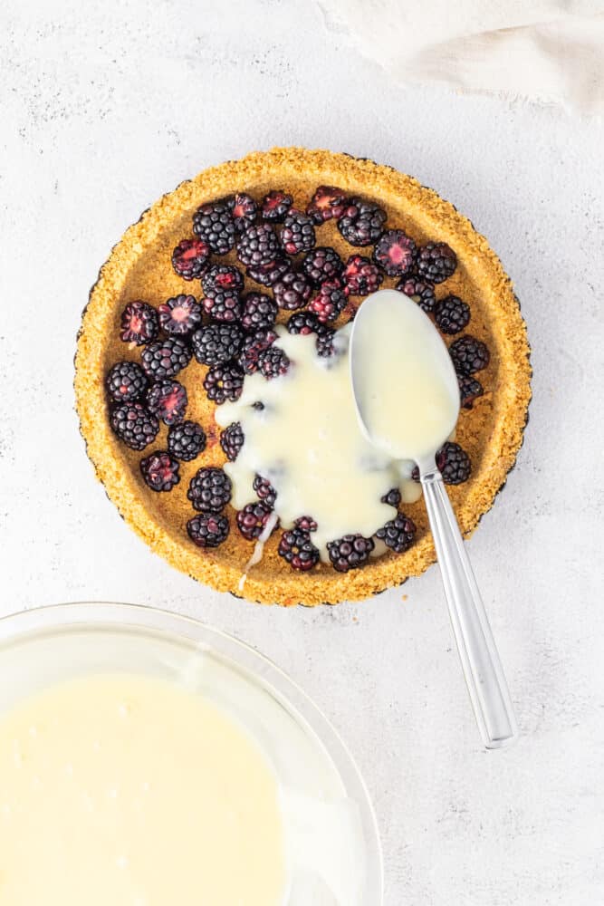 A White Chocolate Blackberry Tart with a spoon next to it.
